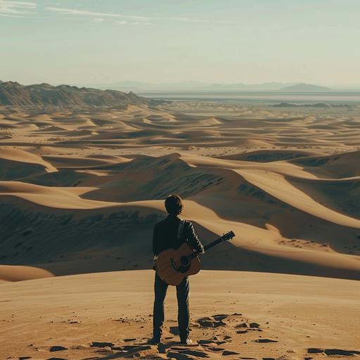 A guitarist stands alone in front of dunes on his journey to the West. Where is west? He wonders.