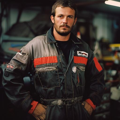 , Mechanic man working in an auto body shop. He wears a black color with a part of red-accented boiler suit.