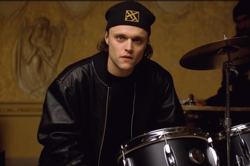1990 screengrab of male model Lars Ulrich, playing on drums, wearing a black oversized hoodie with an embroidered gold Balenciaga logo on the front. The hoodie would be paired with matching black relaxed-fit joggers and white high-top sneakers, creating a comfortable yet stylish look for the drummer., fashion movie scene, Balenciaga commercial --ar 3:2 --v 5