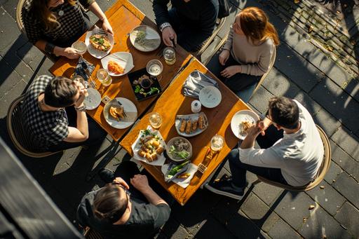 Capture a high-angle, realistic photograph of 5 people enjoying a sunny day on a outdoor restaurant terrace in Amsterdam, The scene should feature individuals with beer glasses, sharing plates of Japanese fingerfood: Yakitori, duck springrolls, spicy harumaki, gyoza, kara age, tatsuta, Emphasize the vibrant atmosphere, ensuring the composition feels genuine and inviting, 35mm FUJIFILM Style, --ar 3:2