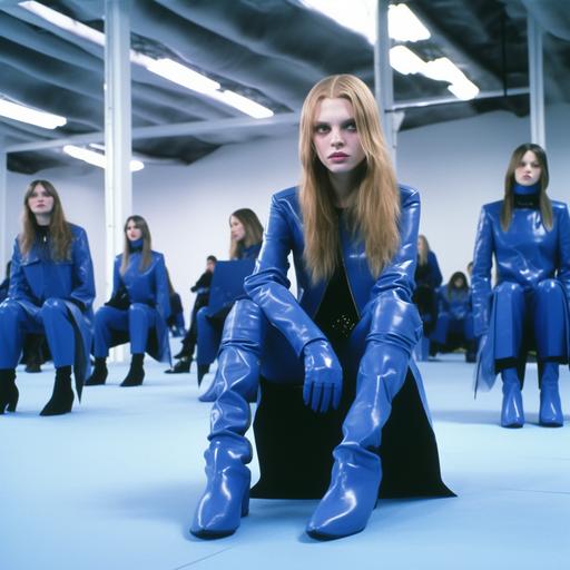 A Juergen Teller photo of 90s Helmut Lang runway four tall very slim women with long flowing hair wearing riotously textured leather uniforms and matching blue boots with design influences from Jil Sander, Prada, Joseph Beuys and Comme des Garçons, lounging on the floor in a room designed by Louise Bourgeois. Blue landscape hologram city background, dramatic use of lighting, cold tonal range, fashion editorial by Helmut Newton in a fashion magazine --s 750