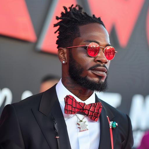 An elegant man shows off his red bowtie on the red carpet of the MTV VMAs