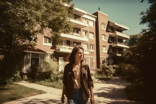 declassified photo, young woman walking in front of apartment, 35mm film, film grain, realistic light --v 5.0 --ar 3:2
