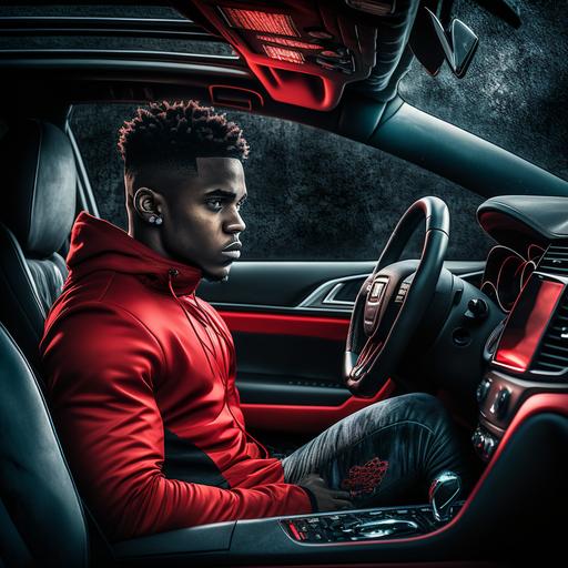 Young man sitting in a dodge srt with red black car interior.