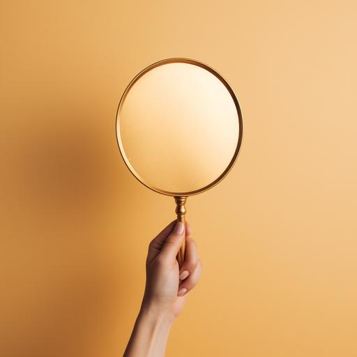 a hand holding a gold hand mirror. minimalist. vintage.