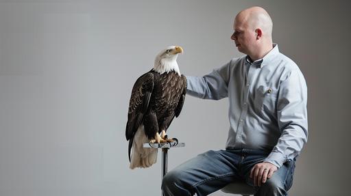 a man wearing a light blue button down shirt sitting on a stool petting a bald eagle sitting on his lap, laboratory setting, clean modern white space, photorealistic, --ar 16:9