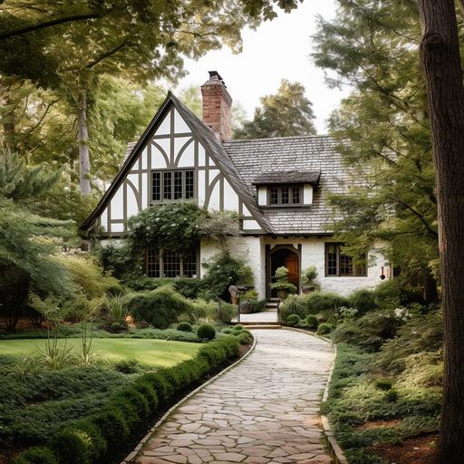 a tudor house with off white trim on a hilltop surrounded by mossy oak trees and rosemary shrubs, driveway in front