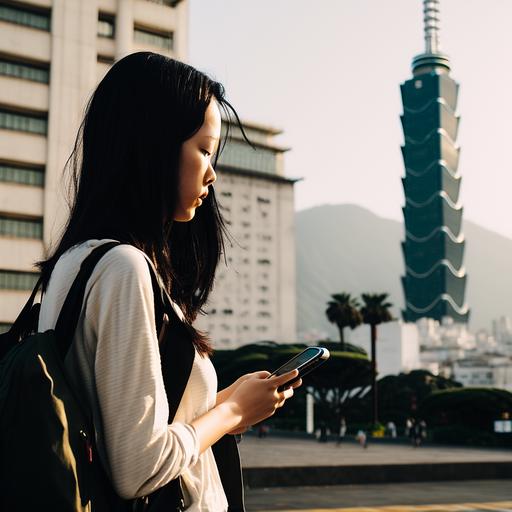 clear sky, an Asian woman with long black hair is using iPhone14 to make a video call, she holds the phone in her right hand, left hand hooks onto her cruel hair, hair swaying in the wind, she stands in front of Taipei 101, sun light shining on her hair from the right side, she wears a white jumpsuit, a black leather jacket, brown high heels, carries a dark green handbag, realistic, 16:9 ratio
