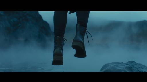 close up of a man's shoes floating with mountains in background, moody environment, fog with back-lit dramatic atmosphere, in the style of Denis Villeneuve --ar 16:9 --v 6.0