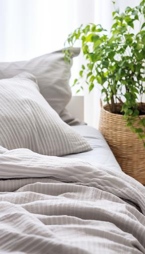 close-up of the finely striped heather gray fabric of a soft duvet placed on a bed in a modern, cozy bedroom interior. soft and bright daylight, touch of rattan, natural materials, plant --ar 4:7