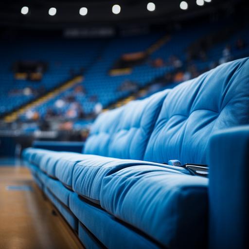 a 4k high resolution hd photograph 3/4 profile view of a blue couch along the courtside seats at a basketball game