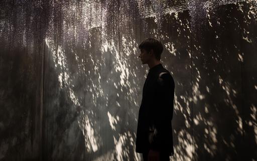 dramatic shot of a wisteria art gallery showcasing maximalist wisteria overgrown architectural luminogram endless rocks portals photography luminosity in Milan, by elsa bleda, minimal Sisyphean male in dior suit, natural sunlight and dark shadows --ar 8:5 --stylize 150 --v 6.0