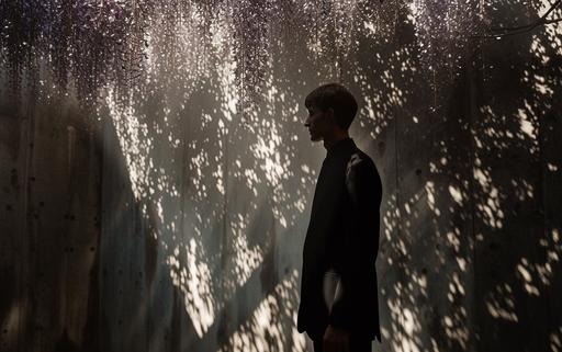 dramatic shot of a wisteria art gallery showcasing maximalist wisteria overgrown architectural luminogram endless rocks portals photography luminosity in Milan, by elsa bleda, minimal Sisyphean male in dior suit, natural sunlight and dark shadows --ar 8:5 --stylize 150 --v 6.0