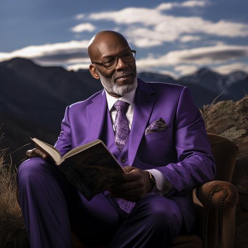 healthy 65 year old black man, with grey and trimmed beard, bald, glasses, sitting down ready a book, wearing a purple suit, background is on top of a mountain