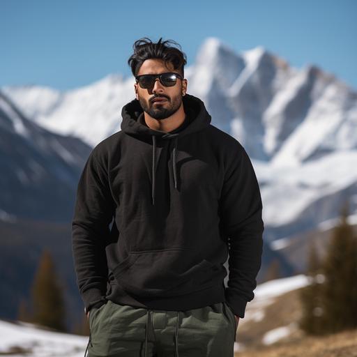 photoshoot of a 6 feet tall brown Indian man wearing high quality, plain black hoodie in military fatigue. Background is in the snow capped mountains.