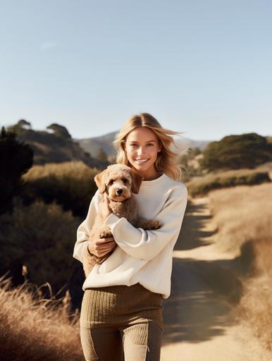 polo Ralph Lauren beautiful blonde hair blue eyes model wearing cream sweatshirt and holding a brown poodle toy dog in her hands with a big smile, in the countryside --ar 3:4