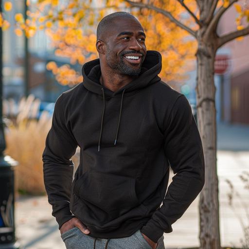 smiling handsome mid 40 yrs old african american man with muscles wearing black hoddie Heavy Blend hoodie - Model Mockup - - outside background high-quality images 85mm Nikon D850 DSLR 8k