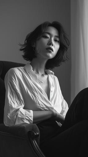 a Korean woman in her 20s sits in black and white in a chair, in the style of celebrity photography, fit body, loose gestures, oversized blouse, maximilian pirner, angelina wrona, crisp and clean, firmin baes, mamiya rb67, cinematic still, attractive --v 6.0 --style raw --ar 1080:1920