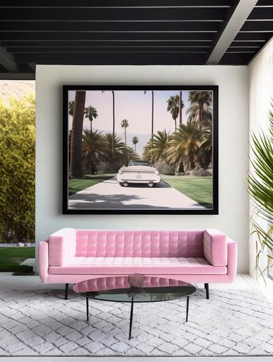 straight on angle photo of a large horizantal glass black frame art of slim aarons hanging on a wall outdoors in the garden area of an expensive spacious scandinavian mediterrenean 70s style palm springs home above a rectangular pink velvet couch, a pastel pink carpet, full of sunshine summer vibes, santorini vibes, white walls , palm tree, next to the couch, the interior designer was inspired by barbie dream house, minimal decor with pops of color, breathtaking scenery with a blue sky and a glistening pool next to the wall, luxury, wheeler collective, vogue, high resolution, design awards, hay furniture, pastel tones --ar 3:4 --q 2 --v 5