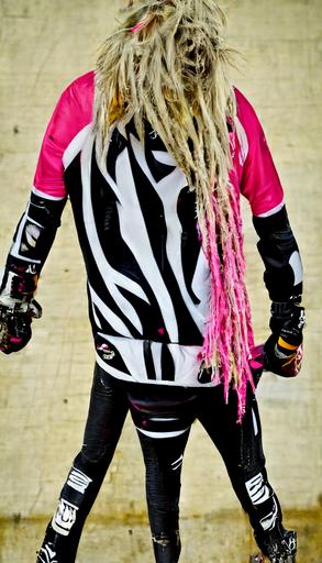tall woman, roller derby, hot pink and black zebra print jacket, metal spikes, bleached blond dreadlocks, —ar 9:16