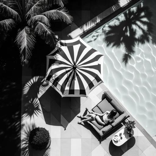 a photo taken from the top of a pool scene with a black and white pool umbrella, a black and white chaise lounge and a woman's legs next to a calm pool
