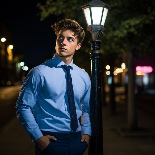 young fit guy wearing blue shirt and a bowtie whilst leaning to a street lamp